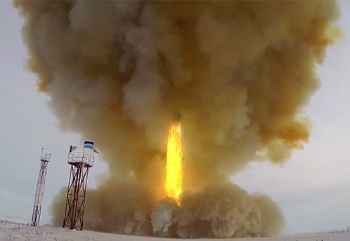 Rocket taking off hardly visible behind the clouds of smoke except a burning yellow column