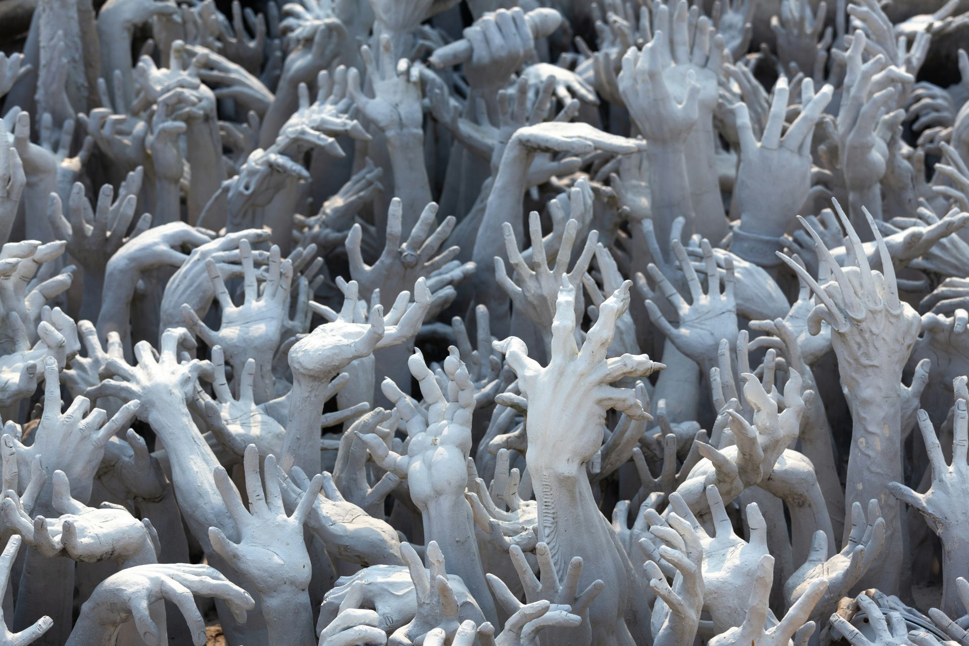 Densely packed grasping hands and claws reaching upwards