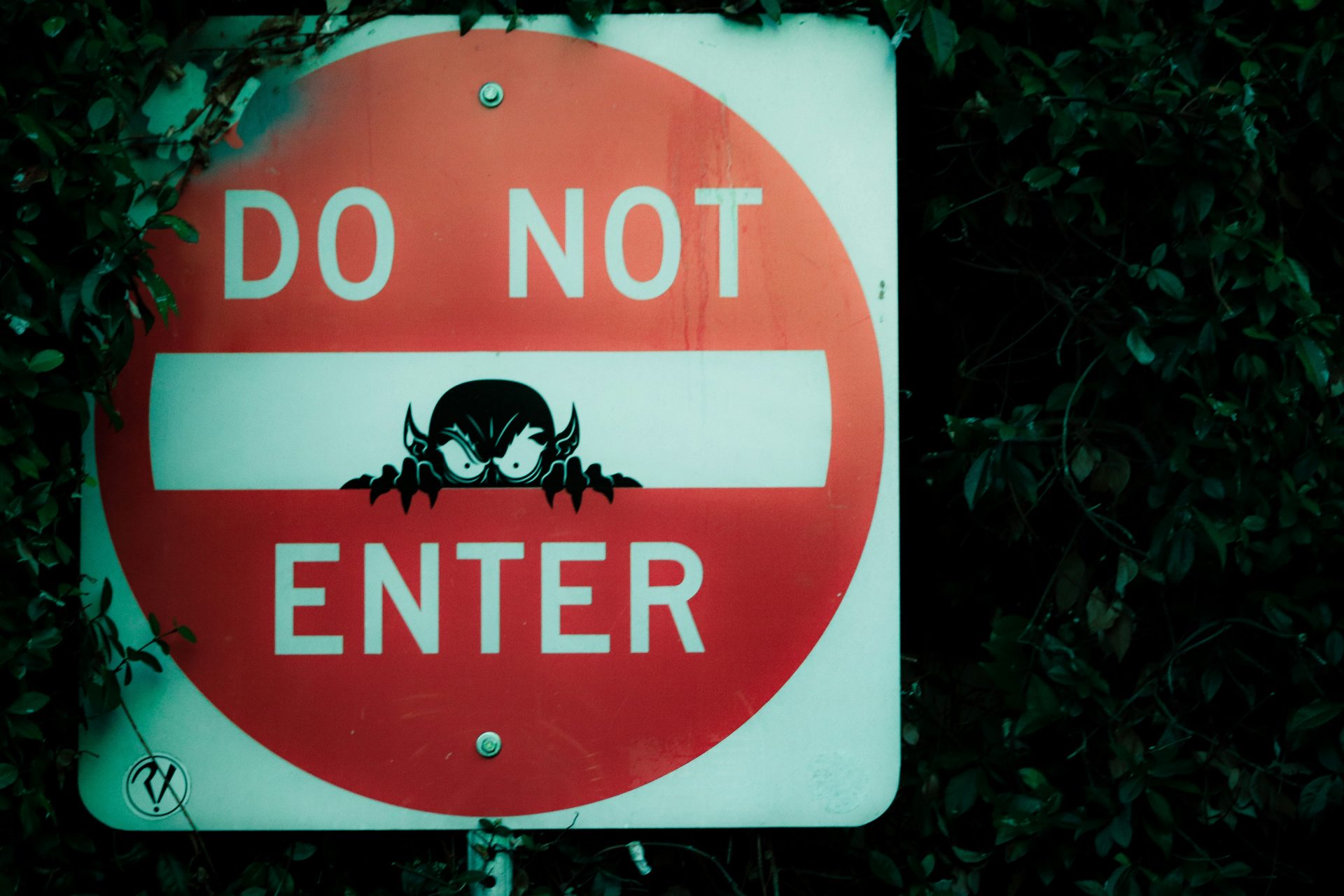 "Do Not Enter" sign with a devil peering out of the middle