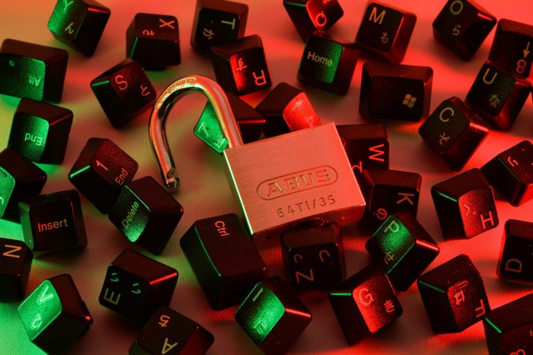 An open padlock sitting on a bunch of computer keys