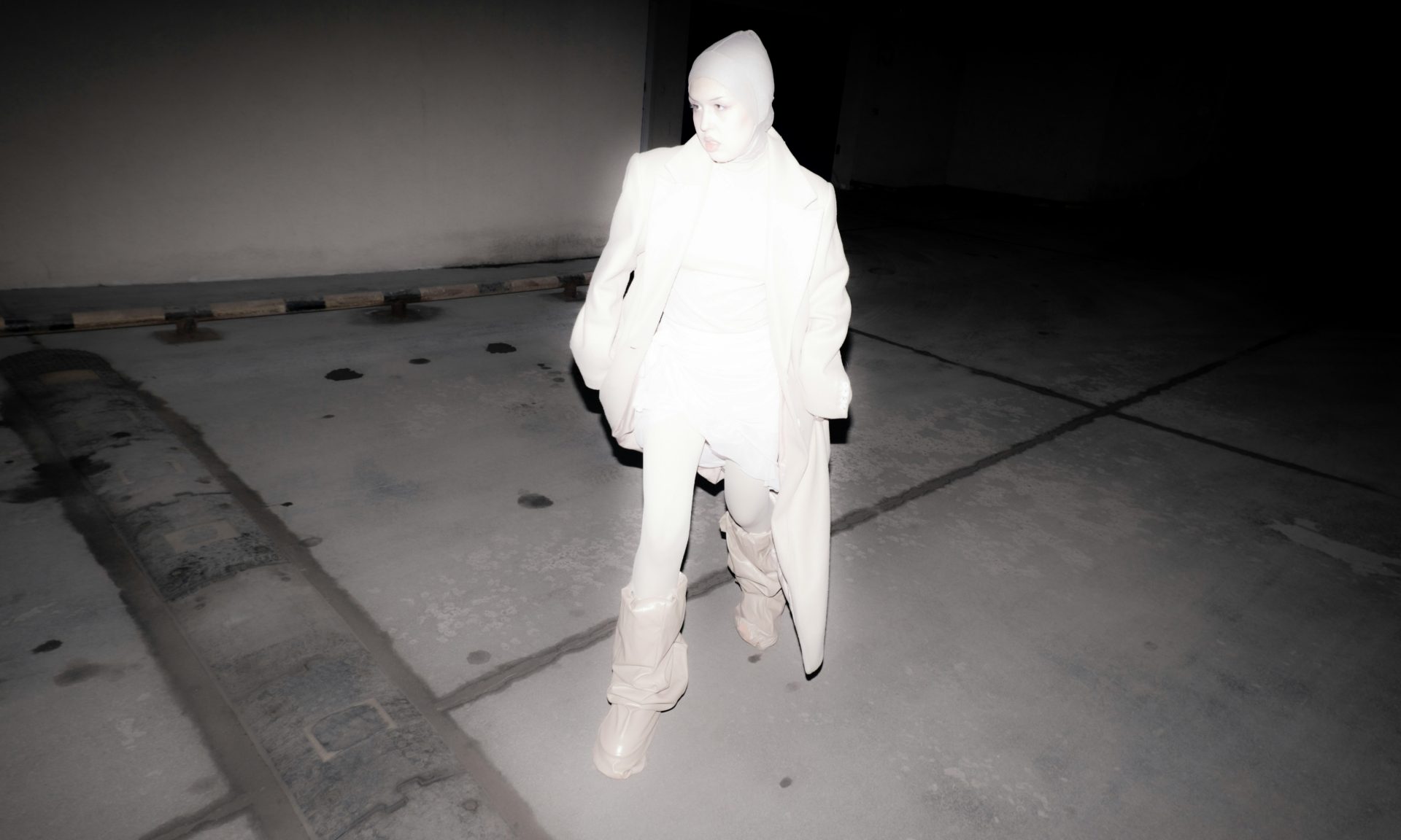 Black and white reverse silhouette of a woman with a crutch, perhaps an infrared or enhanced night vision picture