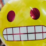 Close-up of a yellow balloon face grimacing awkwardly.