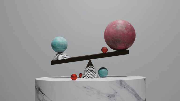A complicated balance of Large and small spheres on top of a cone on a pedestal.