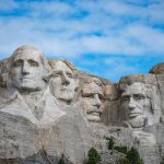 Mount Rushmore - Presidents Washington, Jefferson, (T) Roosevelt, and Lincoln with a clear blue sky.