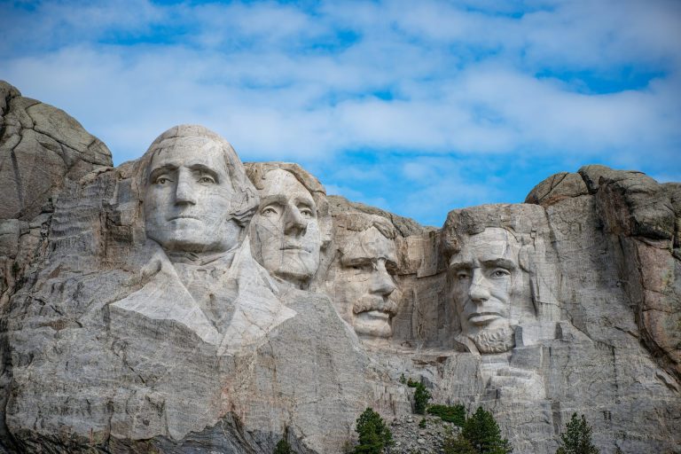 Mount Rushmore - Presidents Washington, Jefferson, (T) Roosevelt, and Lincoln with a clear blue sky.