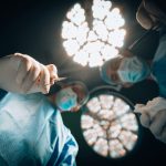Patient's eye view of surgery looking up at two doctors, one about to use a scalpel