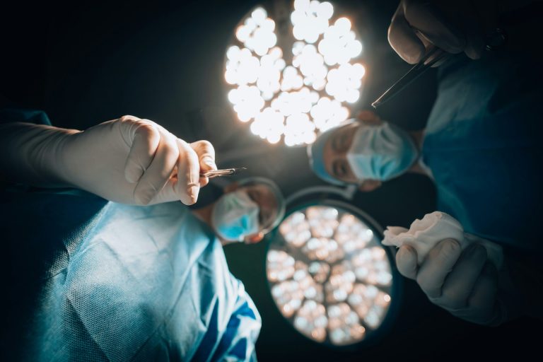 Patient's eye view of surgery looking up at two doctors, one about to use a scalpel