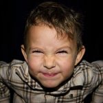 Picture of a young boy with his face scrunched up in a grimace