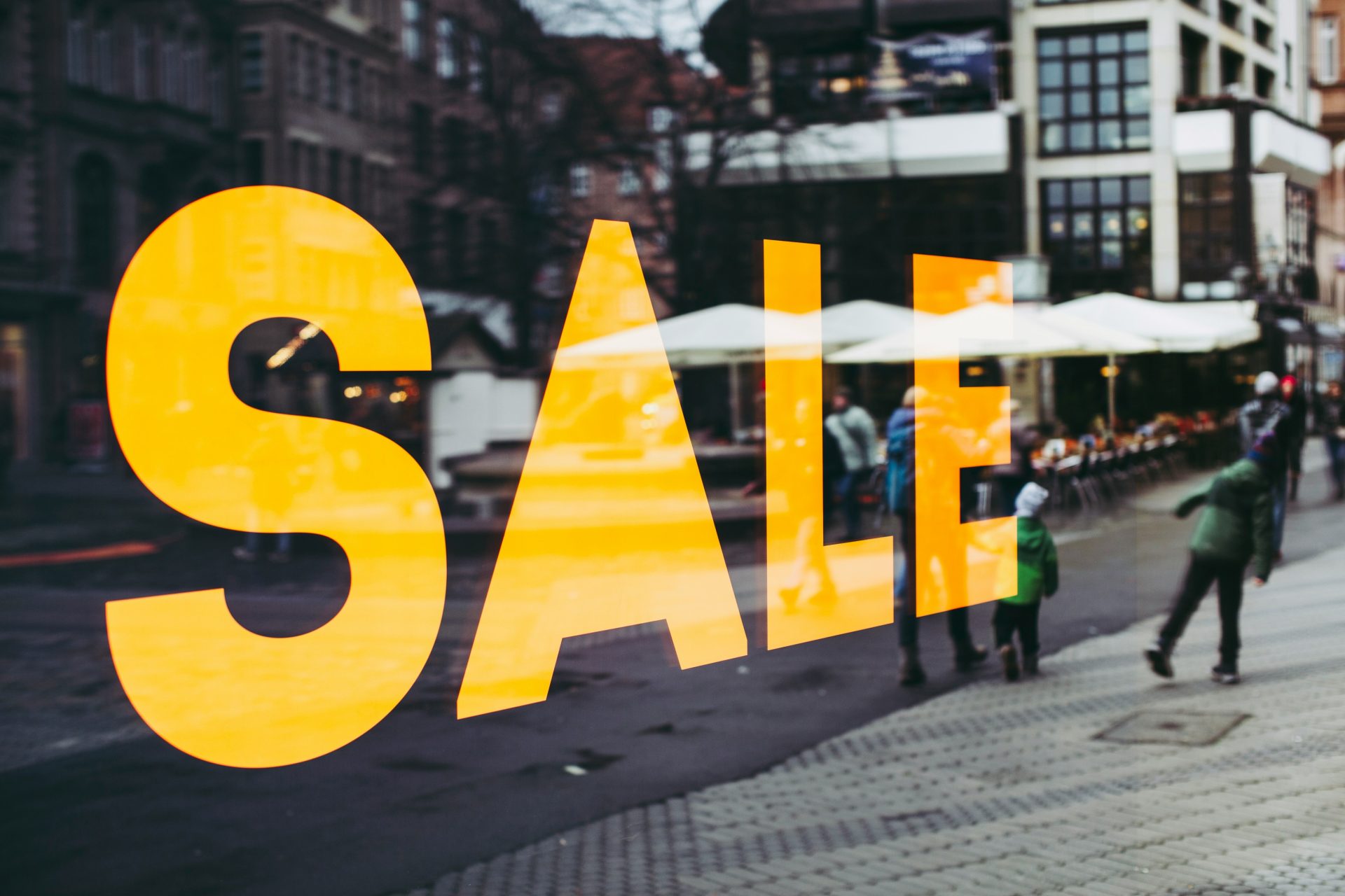 Big Bold SALE in Yellow in front of an urban street scene